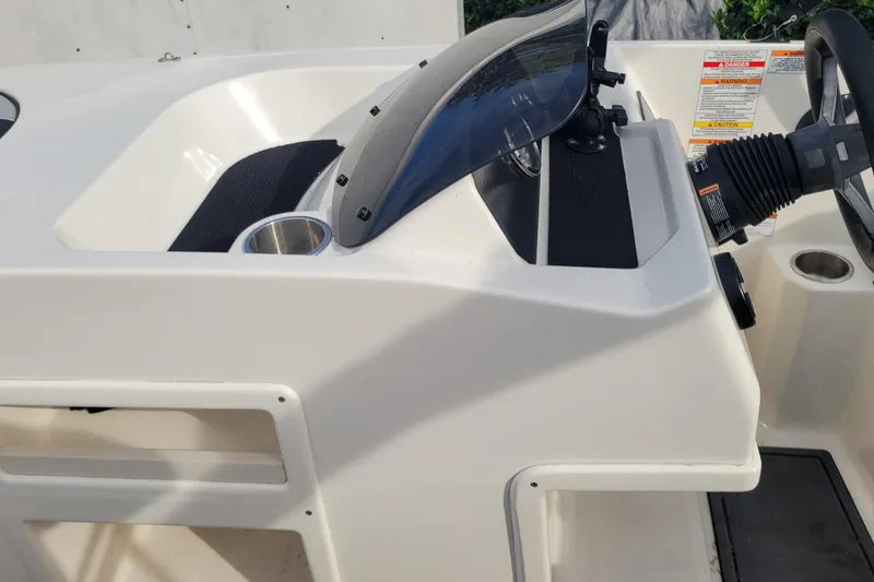 Slide: The Image of 2022 Bayliner Element M17 boat interior with seating and dashboard view. - 12