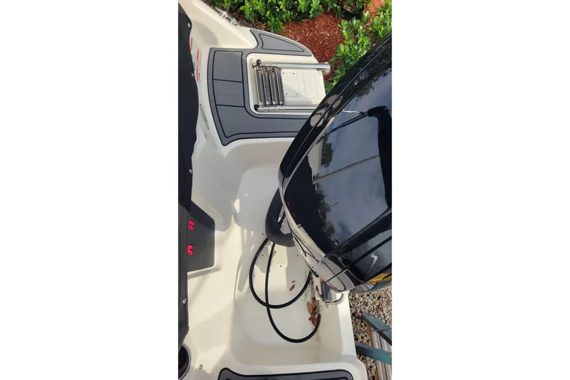 Slide: The Image of 2022 Bayliner Element M17 boat interior with black cover and motor detail. - 22