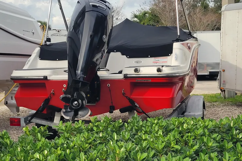 Slide: The Image of 2022 Bayliner Element M17 boat with red hull and covered deck on trailer. - 26