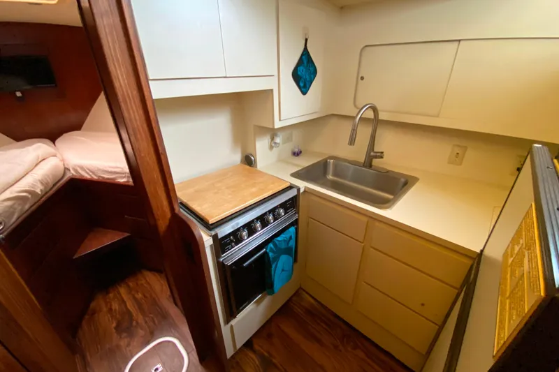 Slide: The Image of Compact kitchen in 1988 Hatteras 40 Double Cabin yacht with sink, stove, and storage. - 10