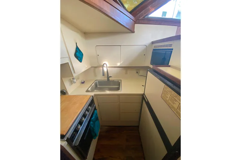 Slide: The Image of 1988 Hatteras 40 Double Cabin kitchen with sink, stove, and refrigerator. - 11