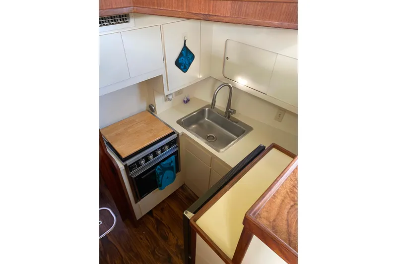 Slide: The Image of Compact kitchen in 1988 Hatteras 40 Double Cabin yacht with sink and stove. - 12