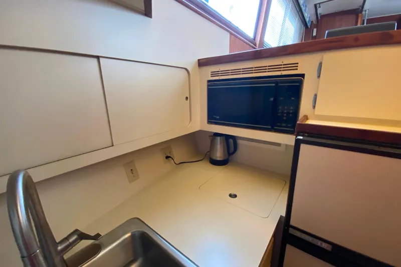 Slide: The Image of 1988 Hatteras 40 Double Cabin kitchen with microwave, sink, and kettle. - 16