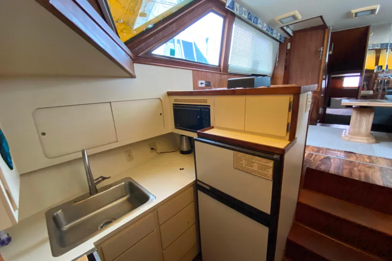 Slide: The Image of 1988 Hatteras 40 Double Cabin yacht interior with kitchenette, sink, and compact appliances. - 17