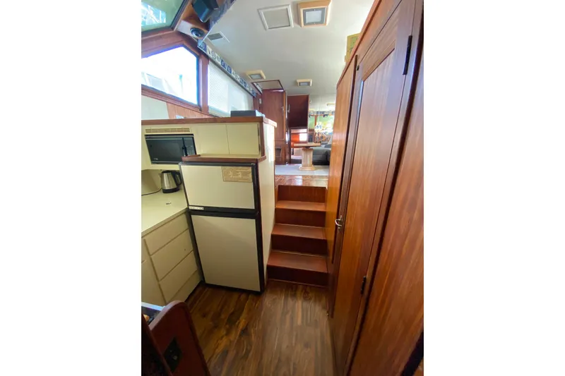 Slide: The Image of Interior of 1988 Hatteras 40 Double Cabin yacht with wood finishes and compact kitchen. - 18