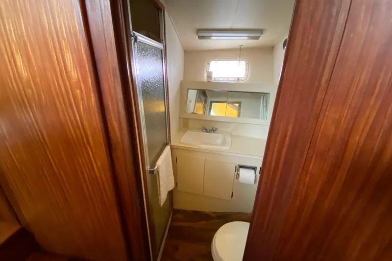 Slide: The Image of 1988 Hatteras 40 Double Cabin bathroom with shower, sink, and wooden accents. - 23