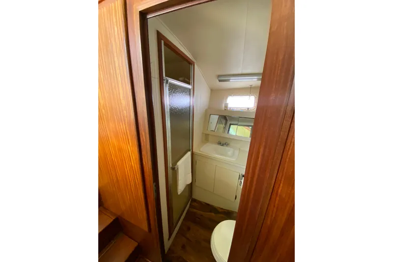Slide: The Image of 1988 Hatteras 40 Double Cabin bathroom with shower, sink, and wooden accents. - 24