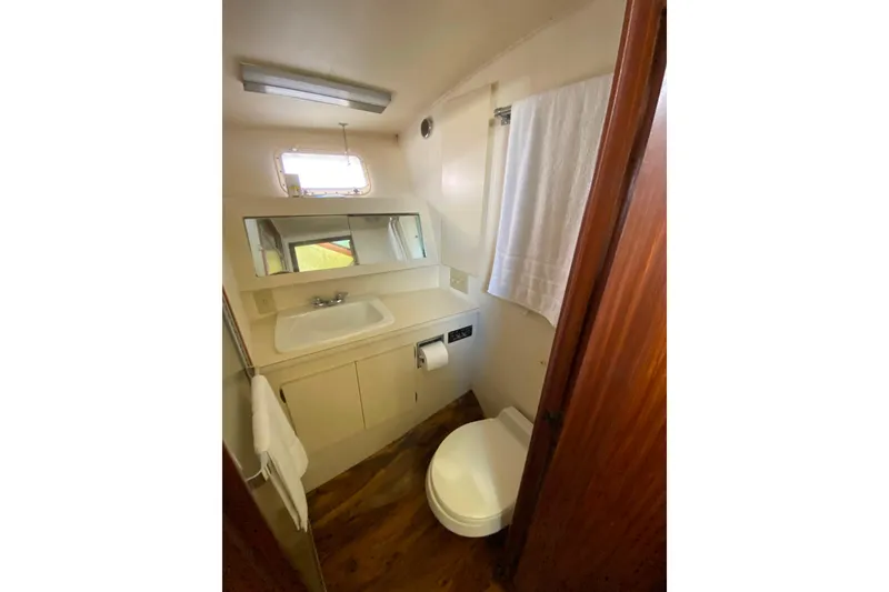 Slide: The Image of 1988 Hatteras 40 Double Cabin bathroom with sink, mirror, and toilet. - 26