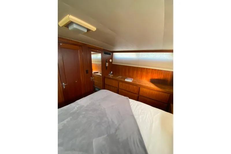 Slide: The Image of 1988 Hatteras 40 Double Cabin interior with wood paneling and cozy bedding. - 31