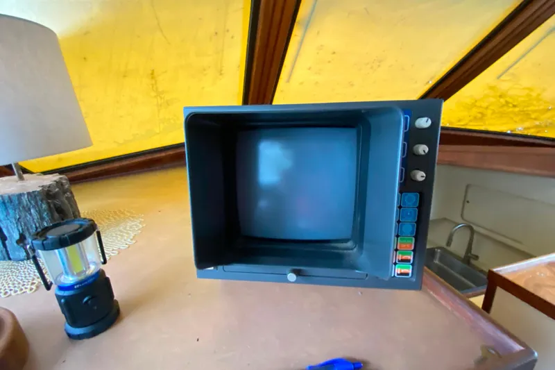 Slide: The Image of Vintage monitor inside 1988 Hatteras 40 Double Cabin yacht, with lamp and lantern nearby. - 37