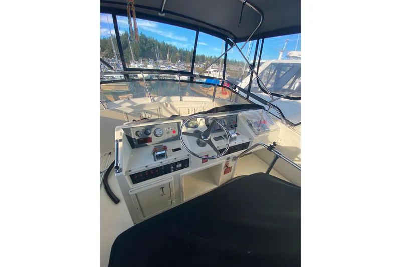 Slide: The Image of 1988 Hatteras 40 Double Cabin helm with steering wheel and control panel, docked in marina. - 40