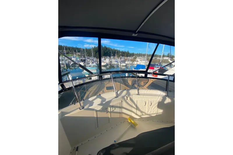 Slide: The Image of 1988 Hatteras 40 Double Cabin yacht interior view at marina, showcasing helm and surrounding boats. - 41
