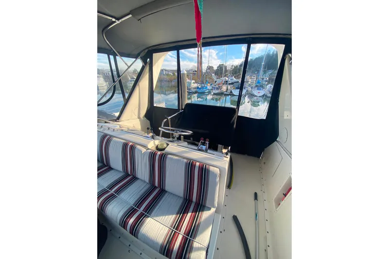 Slide: The Image of 1988 Hatteras 40 Double Cabin interior with striped seating and marina view. - 42