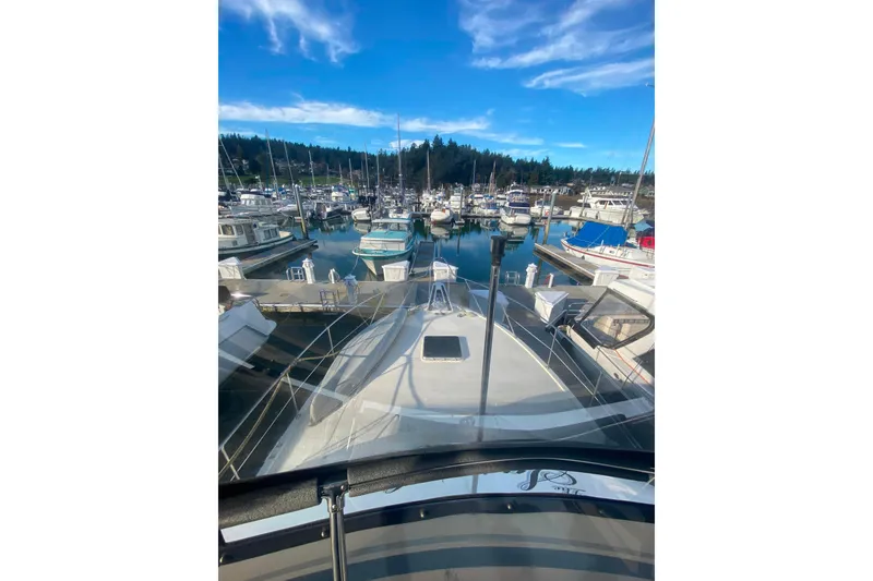 Slide: The Image of 1988 Hatteras 40 Double Cabin yacht docked in a marina under a clear blue sky. - 46