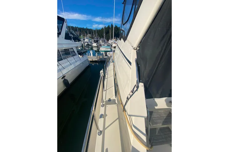 Slide: The Image of 1988 Hatteras 40 Double Cabin yacht docked at a marina under clear blue skies. - 53