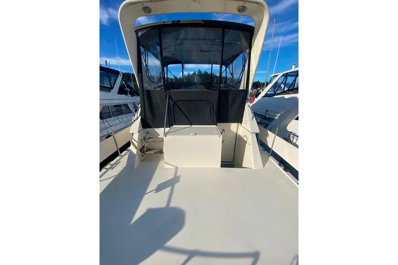 Slide: The Image of 1988 Hatteras 40 Double Cabin yacht with spacious deck and canopy, docked at marina. - 56