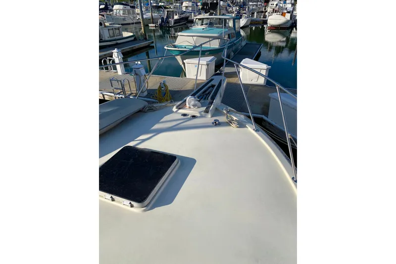 Slide: The Image of 1988 Hatteras 40 Double Cabin yacht docked at marina, showing deck and surrounding boats. - 57