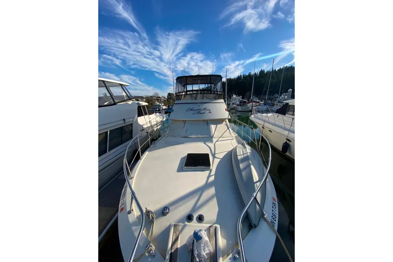 Slide: The Image of 1988 Hatteras 40 Double Cabin yacht docked under a vibrant blue sky. - 58