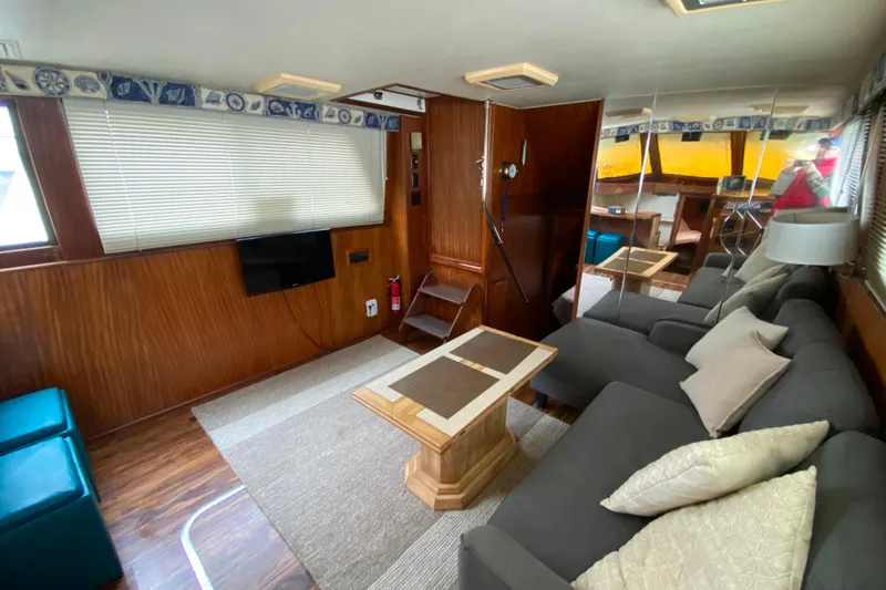 Slide: The Image of 1988 Hatteras 40 Double Cabin interior with cozy seating, wooden accents, and modern amenities. - 6