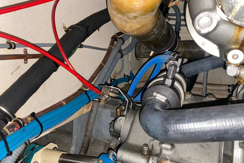 Slide: The Image of Engine room of 1988 Hatteras 40 Double Cabin with visible hoses and wiring. - 66