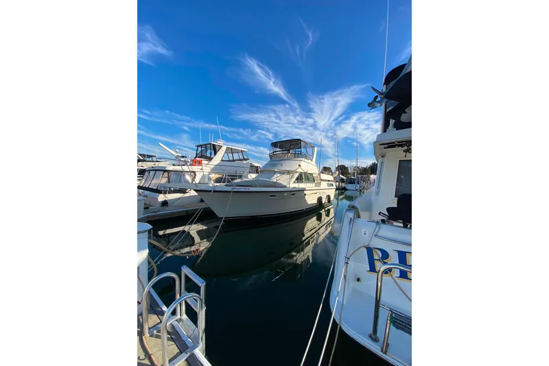 Slide: The Image of 1988 Hatteras 40 Double Cabin yacht docked in a marina under a clear blue sky. - 73