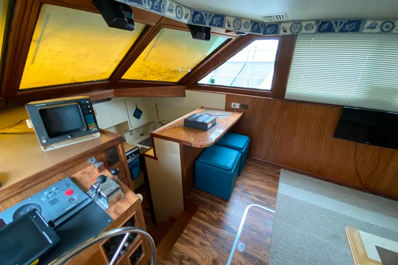 Slide: The Image of 1988 Hatteras 40 Double Cabin interior with helm, seating, and nautical decor. - 9