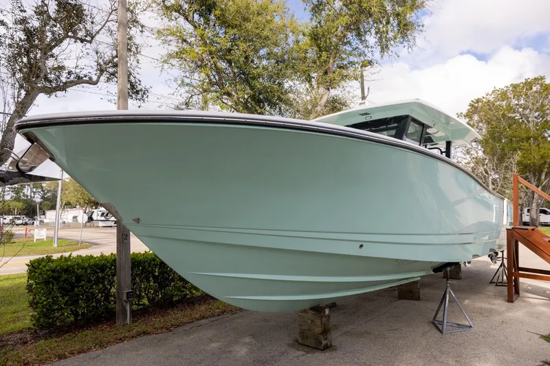 The Image of 2024 Robalo R360 Center Console boat displayed outdoors on stands. - 0