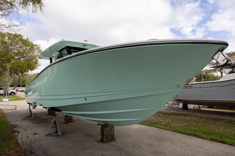 Slide: The Image of 2024 Robalo R360 Center Console boat displayed on stands outdoors. - 1