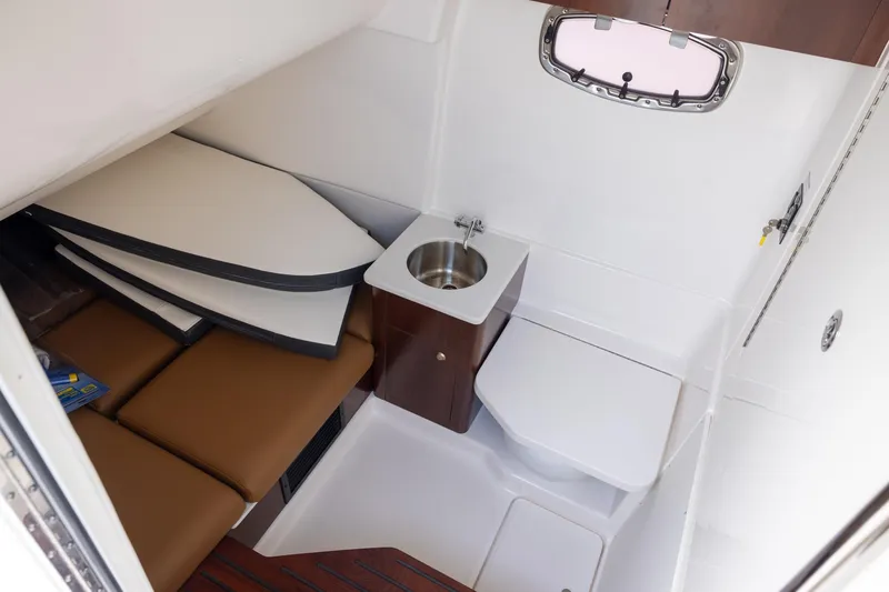 Slide: The Image of 2024 Robalo R360 Center Console cabin with sink, seating, and storage. - 12