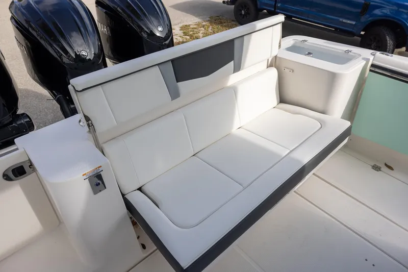 Slide: The Image of 2024 Robalo R360 Center Console boat with white cushioned seating and triple outboard engines. - 6