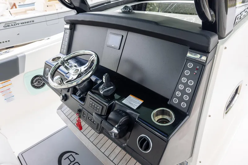 Slide: The Image of 2024 Robalo R360 Center Console helm with modern controls and steering wheel. - 8