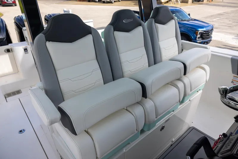 Slide: The Image of 2024 Robalo R360 Center Console boat seating, featuring luxurious white and gray cushioned seats. - 9