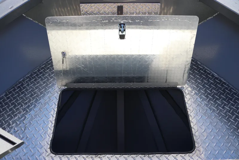Slide: The Image of 2026 Alumaweld Intruder Hard Top 24 boat storage compartment with diamond plate flooring. - 24