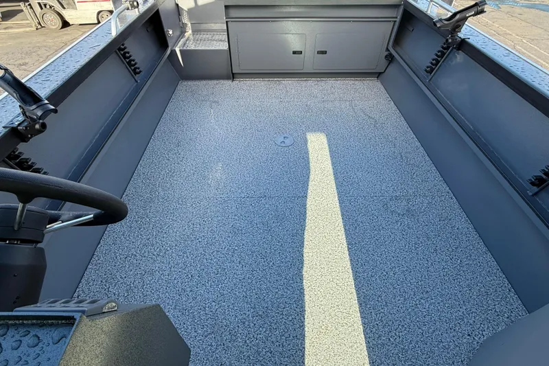 Slide: The Image of 2026 Alumaweld Intruder Hard Top 24 boat interior with spacious deck and steering wheel. - 30