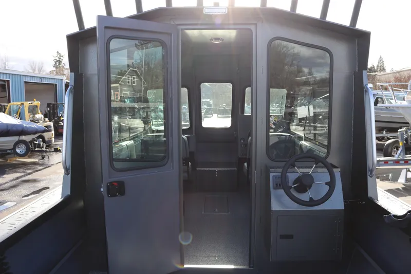Slide: The Image of 2026 Alumaweld Intruder Hard Top 24 boat interior with steering wheel and glass doors. - 6