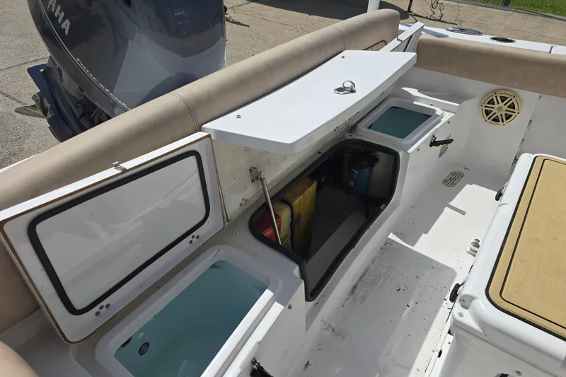 Slide: The Image of 2020 Sportsman Heritage 211 Center Console boat interior with storage compartments open. - 13