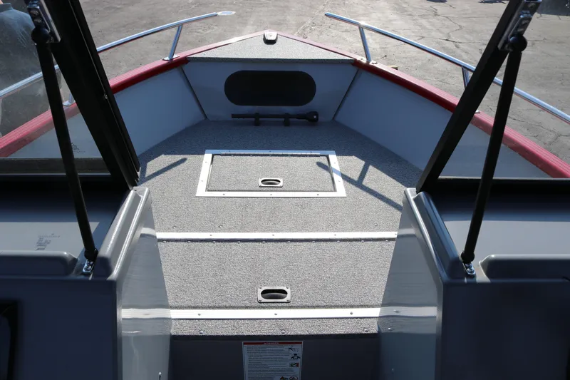 Slide: The Image of 2026 Smoker Caft Pro Tracer 162 boat interior with carpeted deck and storage compartments. - 12