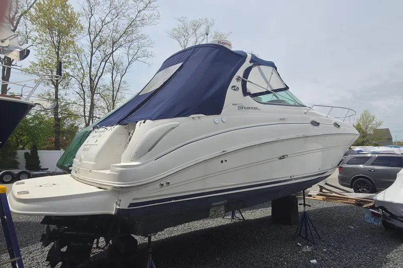 The Image of 2006 Sea Ray Sundancer 280 boat on stands, covered with a blue canopy. - 0