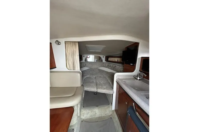 Slide: The Image of Interior of 2006 Sea Ray Sundancer 280, featuring cozy cabin and kitchenette. - 10