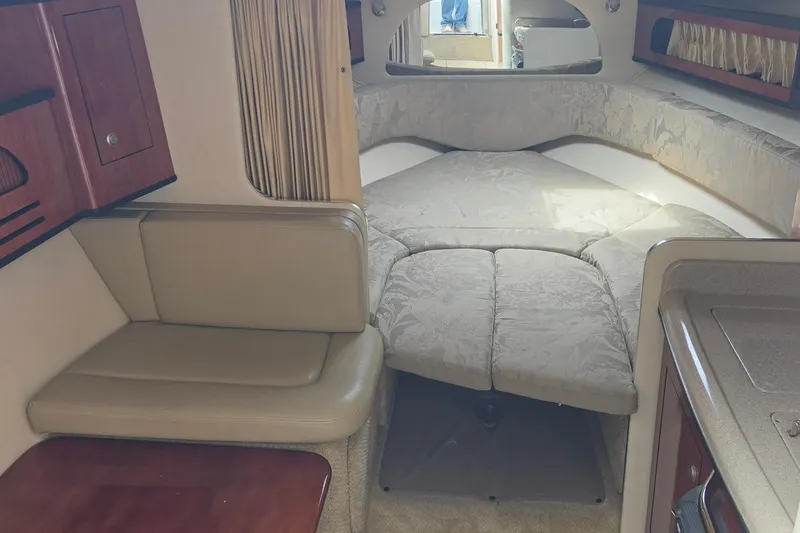 Slide: The Image of Interior of 2006 Sea Ray Sundancer 280, featuring cozy seating and a convertible bed. - 20