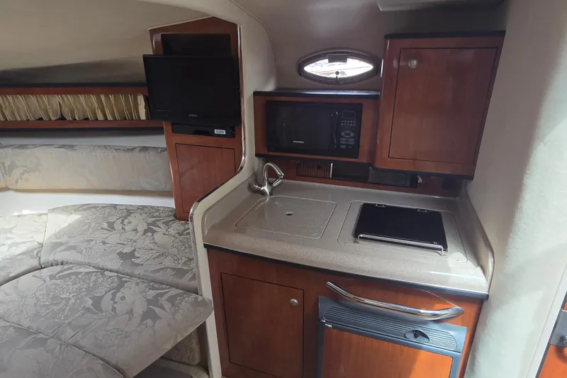 Slide: The Image of 2006 Sea Ray Sundancer 280 interior with kitchenette, TV, and cozy seating area. - 28