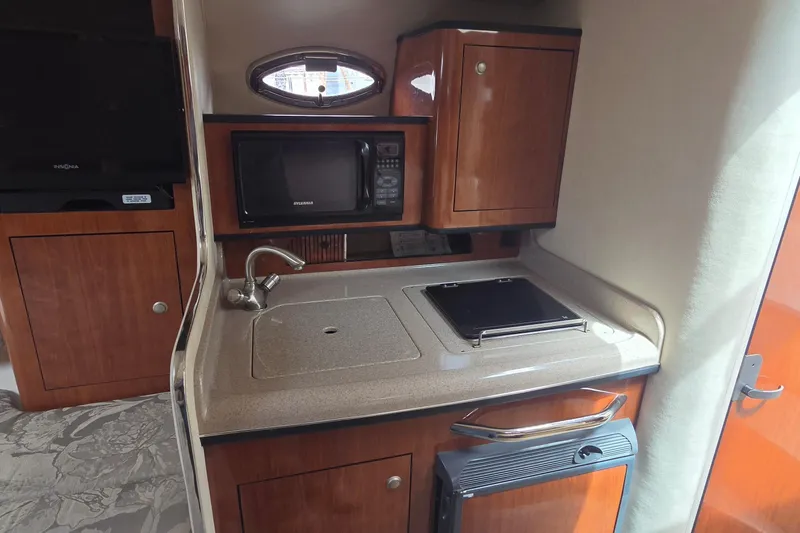 Slide: The Image of 2006 Sea Ray Sundancer 280 galley with sink, microwave, and stove. - 29