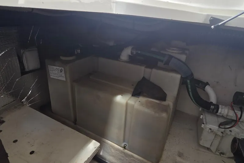 Slide: The Image of Engine compartment of a 2006 Sea Ray Sundancer 280 boat, showing storage tanks and hoses. - 36