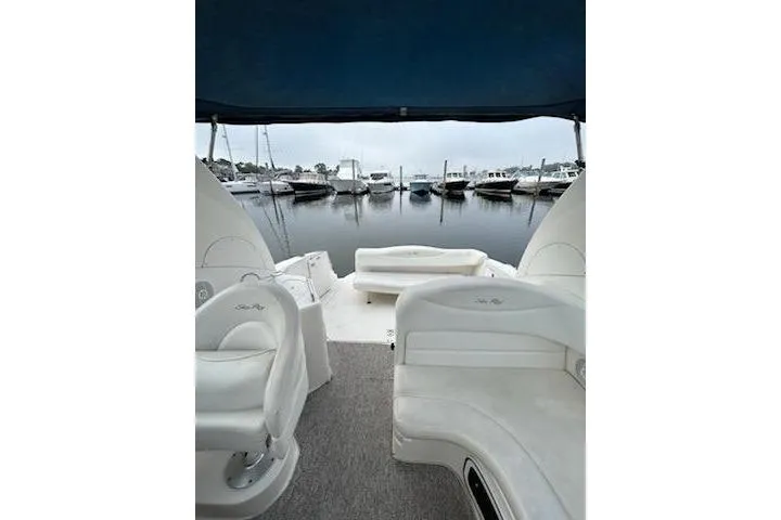 Slide: The Image of 2006 Sea Ray Sundancer 280 interior with marina view, featuring white seating and canopy. - 6