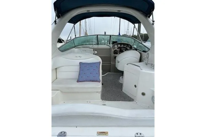 Slide: The Image of 2006 Sea Ray Sundancer 280 interior with seating and helm, featuring a blue cushion. - 7