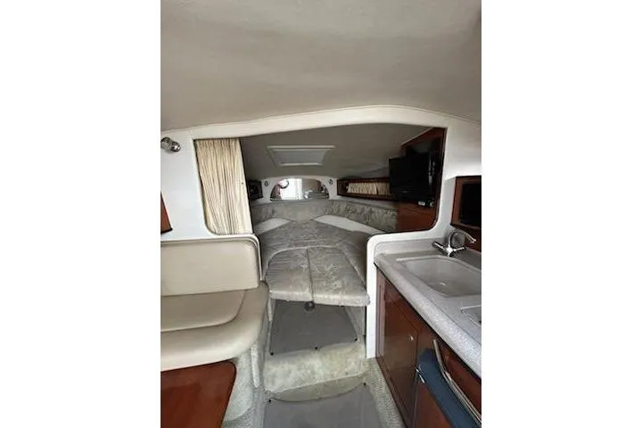 Slide: The Image of Interior of 2006 Sea Ray Sundancer 280, featuring cozy cabin with bed and kitchenette. - 9