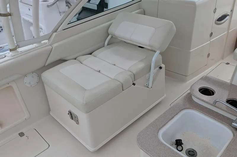 Slide: The Image of 2014 Sailfish 275 DC boat interior with cushioned seating and sink area. - 12