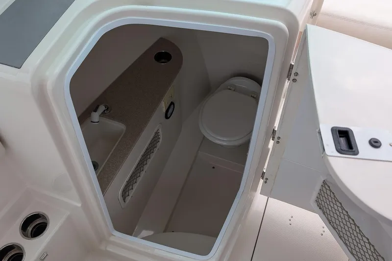 Slide: The Image of 2014 Sailfish 275 DC boat interior with compact bathroom and sink. - 19