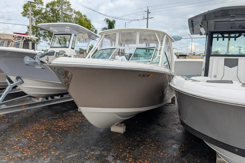 Slide: The Image of 2014 Sailfish 275 DC boat displayed in a marina, surrounded by other vessels. - 2