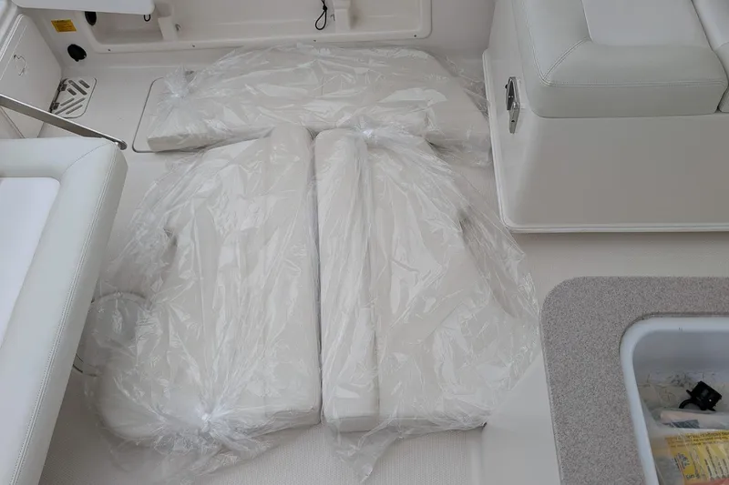 Slide: The Image of 2014 Sailfish 275 DC boat interior with wrapped cushions on deck. - 20